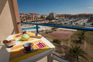 a balcony with a table with a view of a harbor at Résidence Mer & Golf Port Argelès in Argelès-sur-Mer