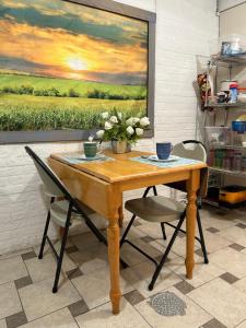 een houten tafel met twee stoelen en een schilderij bij Iowa Nice, Winterset in Winterset
