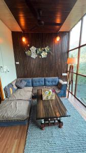 a living room with a couch and a table at Hedony Farmhouse with 2 Bedrooms and Swimming pool in Rishīkesh