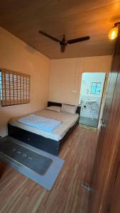 a small bedroom with a bed and a window at Hedony Farmhouse with 2 Bedrooms and Swimming pool in Rishīkesh
