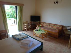 a living room with a couch and a table at Tompras Village in Paralia Demonias
