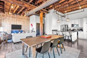 an open kitchen and dining room with a wooden table and chairs at Brick & Bed, Riverfront Lofts, PC 206 in Saint Louis