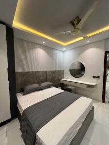 - une chambre avec un lit et un ventilateur de plafond dans l'établissement Travellers Heaven 2BR APT Gulshan Iqbal 13-E, à Karachi