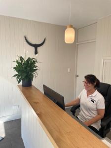 a woman sitting at a bar in an office at The Black Bull Motel in Traralgon