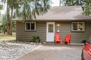 ein kleines Haus mit zwei roten Stühlen davor in der Unterkunft Beach Acres Resort in Parksville