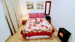 1 dormitorio con 1 cama con manta roja y blanca en Mouton Blanc Campos do Jordão en Campos do Jordão
