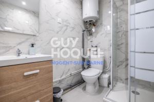 uma casa de banho branca com um WC e um chuveiro em Studio lumineux et silencieux proche Paris et Disneyland em Nogent-sur-Marne