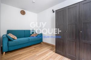um sofá azul num quarto com um armário em Studio lumineux et silencieux proche Paris et Disneyland em Nogent-sur-Marne