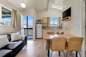 a living room and kitchen with a table and a couch at Tasman Holiday Parks - Merimbula in Merimbula