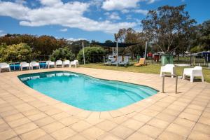 a large swimming pool with chairs and a table at Tasman Holiday Parks - Albany in Albany