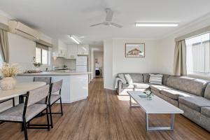 a living room with a couch and a table at Tasman Holiday Parks - Merimbula in Merimbula