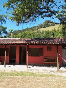 a red house with a mountain in the background at Villa Pareto Guest House in Macaé
