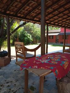 a table and a chair under a pavilion at Villa Pareto Guest House in Macaé