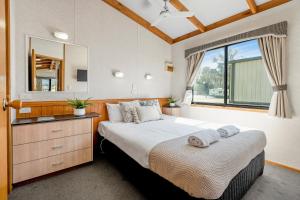 a bedroom with a large bed and a large window at Tasman Holiday Parks - Merimbula in Merimbula