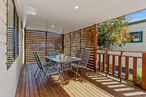 a wooden balcony with a table and chairs on it at Tasman Holiday Parks - Merimbula in Merimbula +81 photos