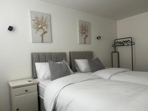 1 dormitorio con 2 camas con sábanas blancas en Pointcastle, en West Thurrock