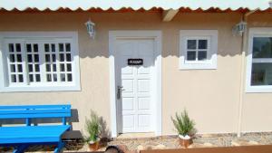 a house with a blue bench in front of a door at Mouton Blanc Campos do Jordão in Campos do Jordão