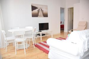 uma sala de estar branca com uma mesa e cadeiras brancas em Cool Tailor Made 2 Bedroom Apartment em Lisboa