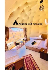 a room with two beds and a table in a tent at Angelina Wadi Rum camp in Wadi Rum