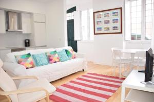 a living room with a white couch and a table at Cool Tailor Made 2 Bedroom Apartment in Lisbon