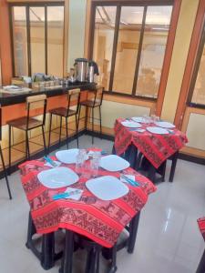 ウユニにあるHostal Beds of salt Gaのレストランの赤いテーブルクロスが付いたテーブル2台