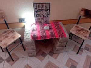 una mesa con dos sillas y un cartel en ella en Hostal Beds of salt Ga en Uyuni