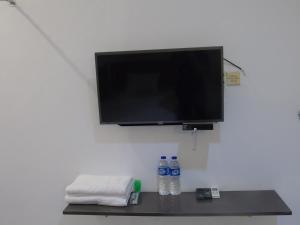 TV y 2 botellas de agua en una mesa en Hotel Permata Zamrud, en Cirebon 15 fotos más