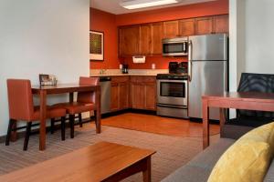 cocina con nevera de acero inoxidable y mesa en Residence Inn by Marriott Albany East Greenbush/Tech Valley en East Greenbush