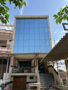 un edificio con una fachada de cristal con escaleras delante en OYO Hotel Red Cross(banquet&restra) en Kānpur
