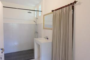 烏布的住宿－烏布阿雷之家旅館，浴室配有淋浴帘和盥洗盆。