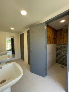 un bagno con vasca, lavandino e doccia di Moon Bar Hostel a Port Barton