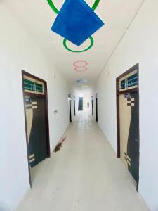 an empty corridor in an office building with a blue ceiling at OYO Friends Hotel in Rewāri