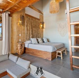een slaapkamer met een bed en een bank bij Mare mío Hotel Boutique in Puerto Arista
