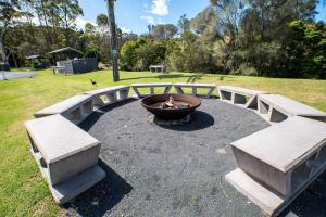 een groep banken in een park met een vuurplaats bij Tasman Holiday Parks - Merimbula in Merimbula