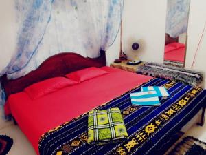 a bedroom with a red bed with a blue blanket at Nature Hub Ella in Ella