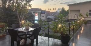 a patio with a table and chairs on a balcony at My Place Guest House Manado in Manado