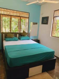 1 dormitorio con 1 cama grande con sábanas azules en Water Pearl, Kosgama, Seetawaka, en Kosgama