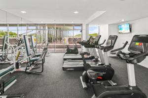 un gimnasio con varias cintas de correr y máquinas cardiovasculares en 219 Harbour Lights with Ocean Views en Cairns
