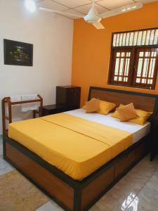 1 dormitorio con 1 cama grande con sábanas amarillas en Water Pearl, Kosgama, Seetawaka, en Kosgama