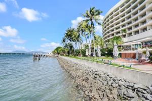 una playa junto a un gran edificio con palmeras en 219 Harbour Lights with Ocean Views en Cairns