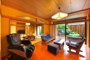 - un salon avec des chaises, une table et une télévision dans l'établissement Kagetsutei, à Shimoda