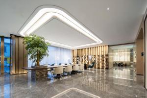 a conference room with a table and chairs and a plant at Atour Hotel Shanghai Pudong Airport Zhunan Road in Nanhui