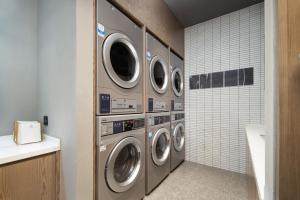 a laundry room with four washing machines in it at Atour Hotel Shanghai Pudong Airport Zhunan Road in Nanhui