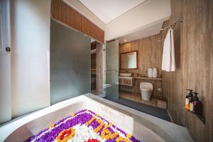 a bathroom with a bath tub with a rug at Ini Vie Villa Legian by Ini Vie Hospitality in Legian