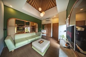 uma sala de estar com um sofá e uma televisão em Ini Vie Villa Legian by Ini Vie Hospitality em Legian