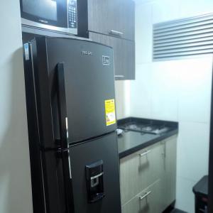 una nevera negra en una cocina con microondas en LA CASA DEL CABLE -Atractivo Único Sector Cable 104-, en Manizales