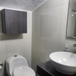 Baño blanco con aseo y lavamanos en LA CASA DEL CABLE -Atractivo Único Sector Cable 104-, en Manizales