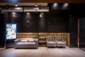 ein Zimmer mit 2 Stühlen, einem Sofa und einem Bildschirm in der Unterkunft Calligraphy Greenway Hotel in Taichung