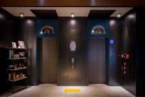 una habitación con dos ascensores con un teléfono móvil en Calligraphy Greenway Hotel en Taichung