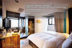 a bedroom with a large white bed and a desk at Calligraphy Greenway Hotel in Taichung